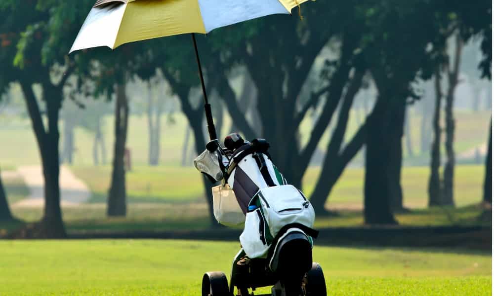 How do I attach the umbrella holder to my Clicgear golf cart?